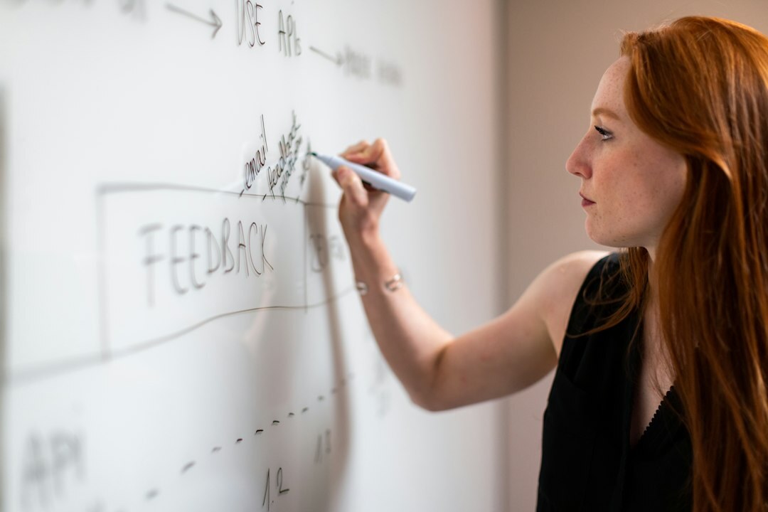 Small group of colleagues in a bright office having a discussion at a whiteboard